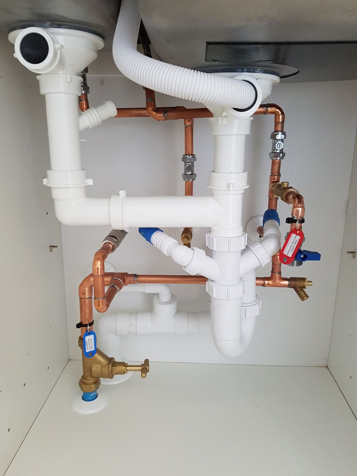 Copper and waste pipework under a kitchen sink
