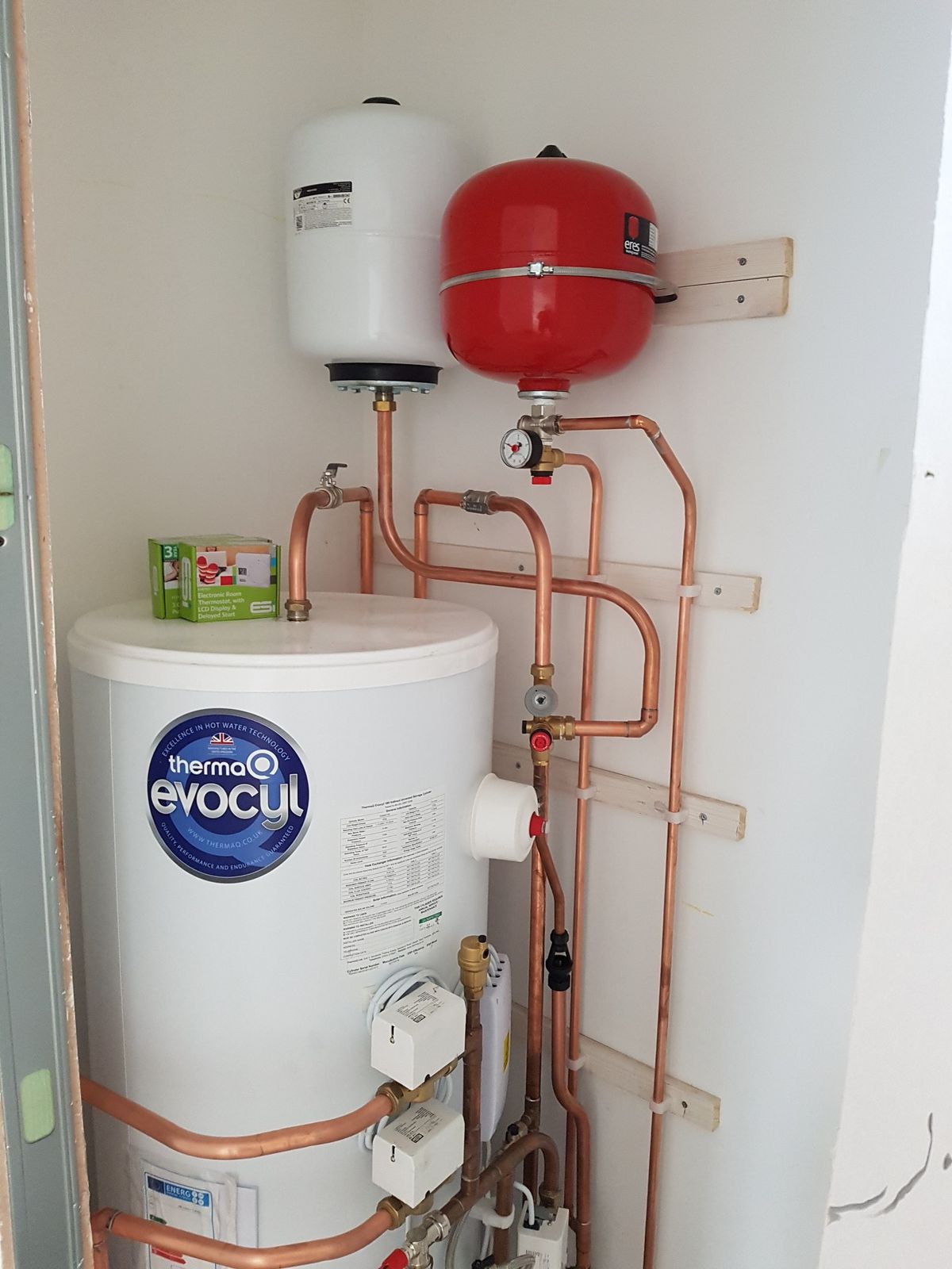 An unvented hot water cylinder installed with copper pipework and an expansion vessel
